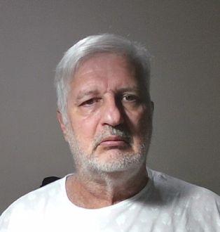 Homem branco de cabelos grisalhos, vestindo camisa branca