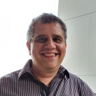 Homem branco, cabelo curto e escuro, de camisa azul listrada de branco